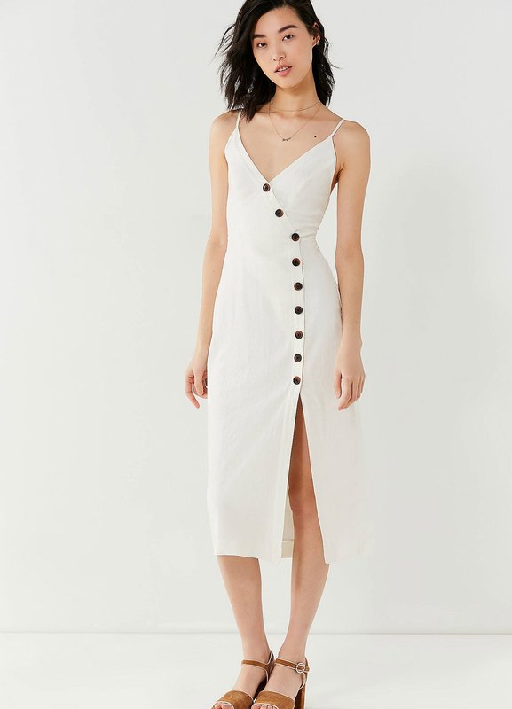 Asymmetrische knopindeling op een witte jurk