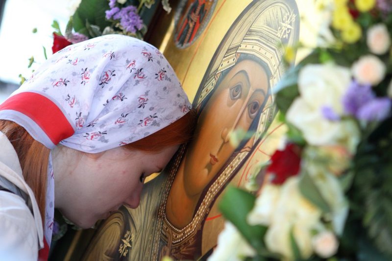 Dívka se ukloní na ikonu Panny Marie