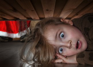 Vystrašené dieťa sa skrýva pod posteľou