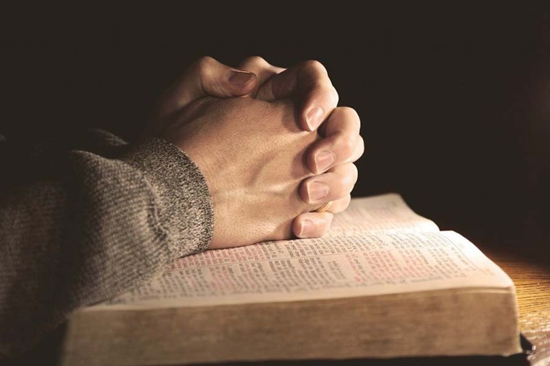 Modlí ruce na bible