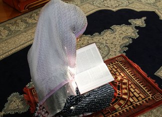 Moslimvrouw die voor huis het schoonmaken bidt