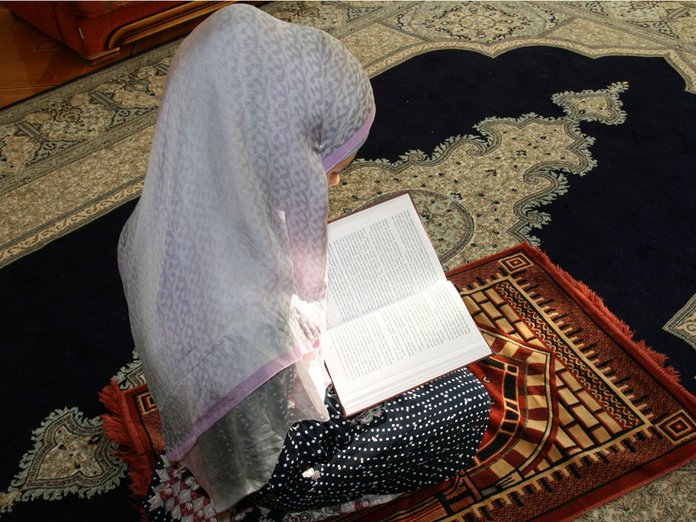 Muzulmán nő imádkozik a ház takarításáért