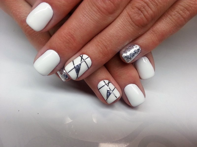 Biały manicure z geometrią i srebrnym brokatem.