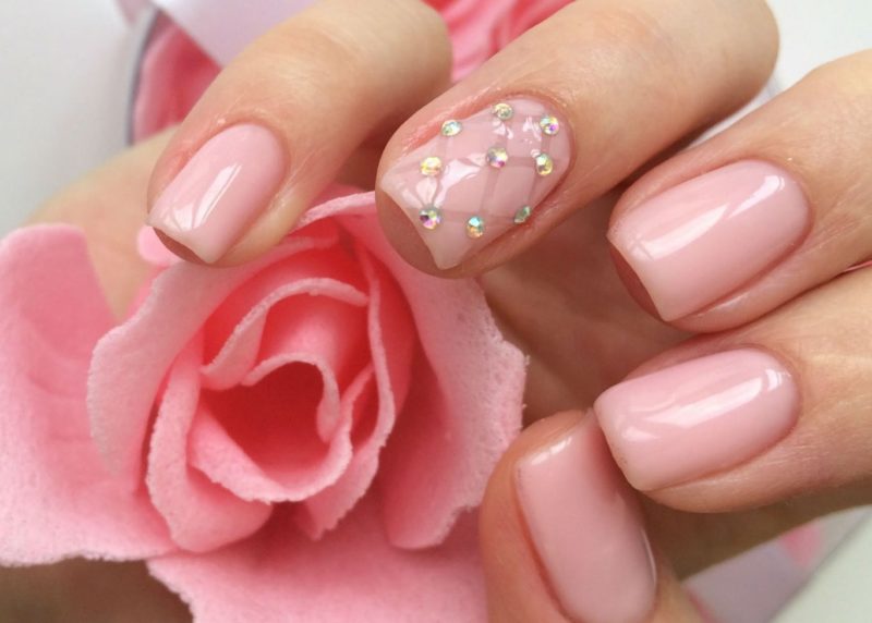 Trendy roze manicure met strass steentjes.