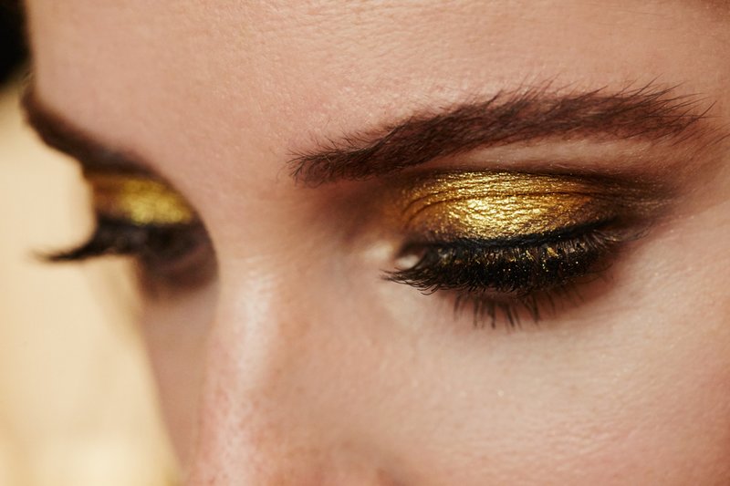 Modieuze make-up met gouden glans