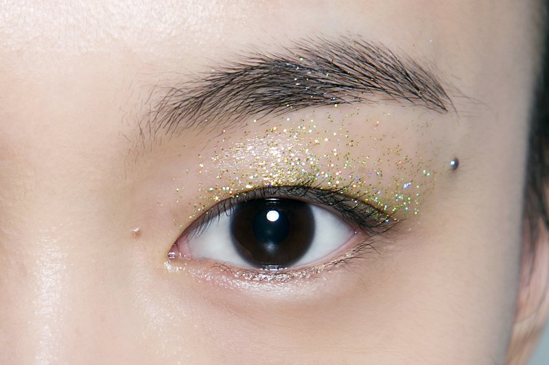 Gyldne øyenvipper på øyelokkene for et asiatisk utseende
