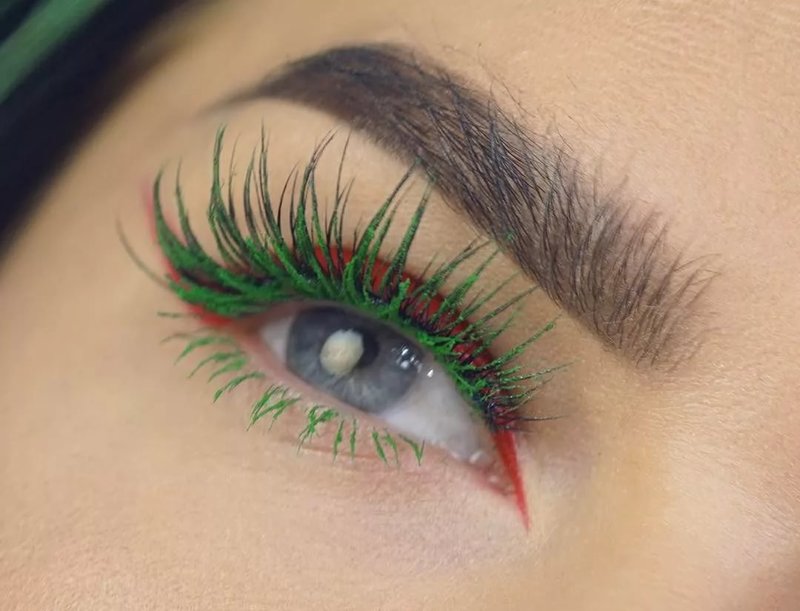 Een ongebruikelijke combinatie van rode pijlen en groene wimpers in make-up