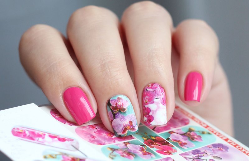 Kleurrijke manicure met bloemenstickers.