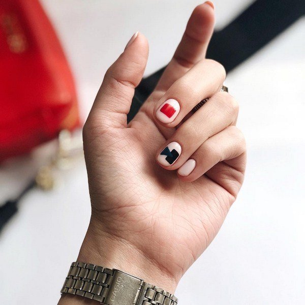 Geometrische manicure in zwarte en rode kleuren op basis van naakt.