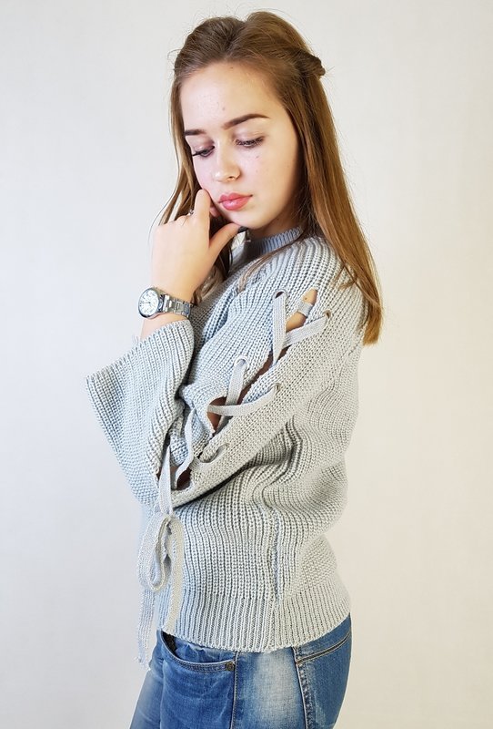 Cô gái mặc áo len có dây buộc dọc theo tay áo