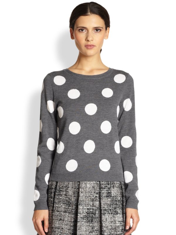 Fată în pulover și fustă cu imprimeu de mazăre