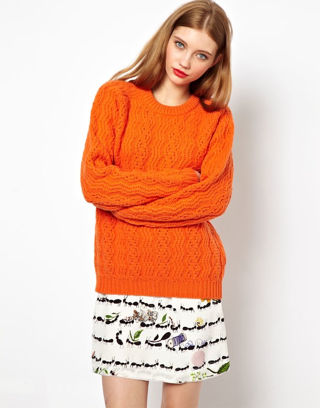 Fată în pulover și fustă portocalie