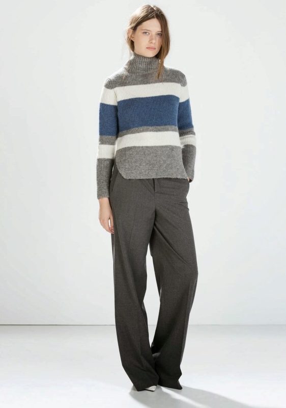 Fată într-un pulover cu dungi orizontale și pantaloni.