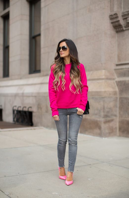 Fată într-un pulover roz strălucitor și blugi skinny