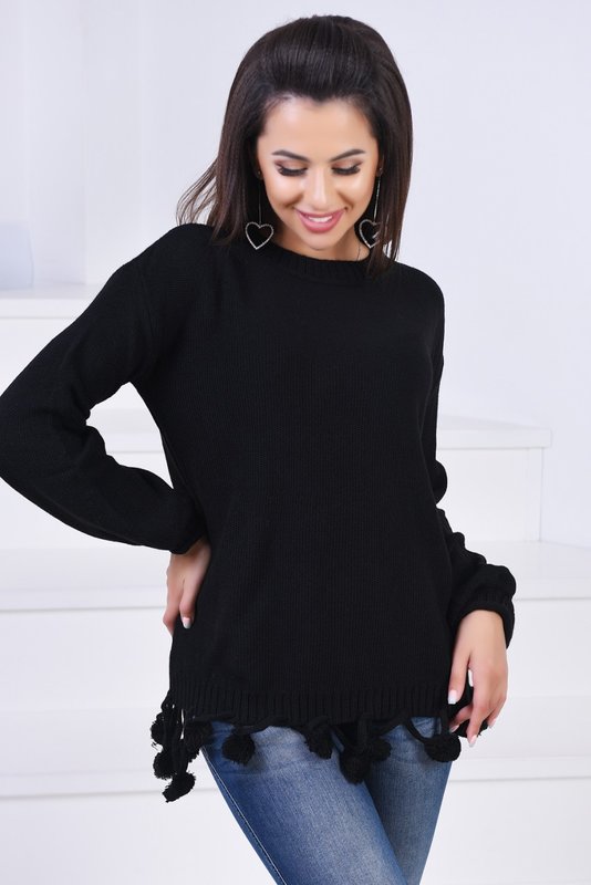 Mergaitė juodame megztinyje su pompomis ant hem