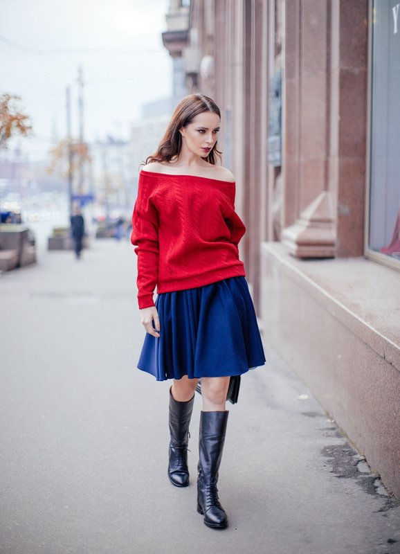 Dívka ve svetru s holými rameny a sukní.