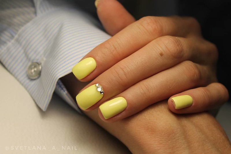 Gevoelige gele manicure met strass steentjes.