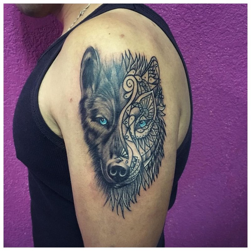 Mieszanka stylów - tatuaż wilka na ramieniu mężczyzny