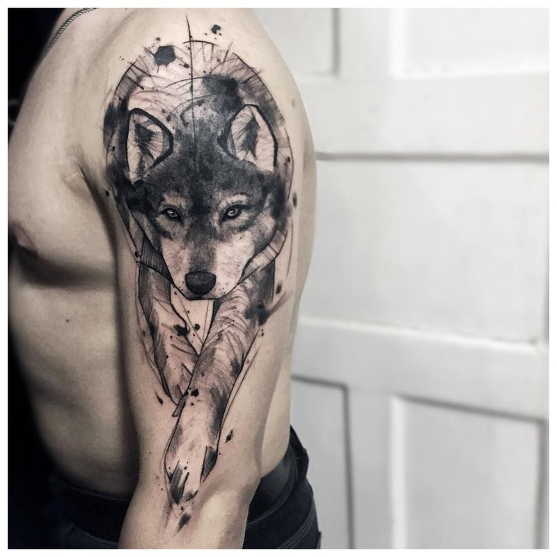 Loup accroupi - tatouage sur le bras d’un homme
