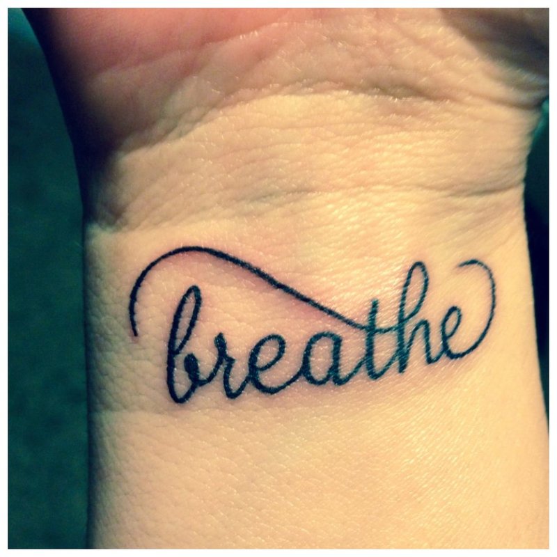 Oddychaj - napis na tatuaż na nadgarstku