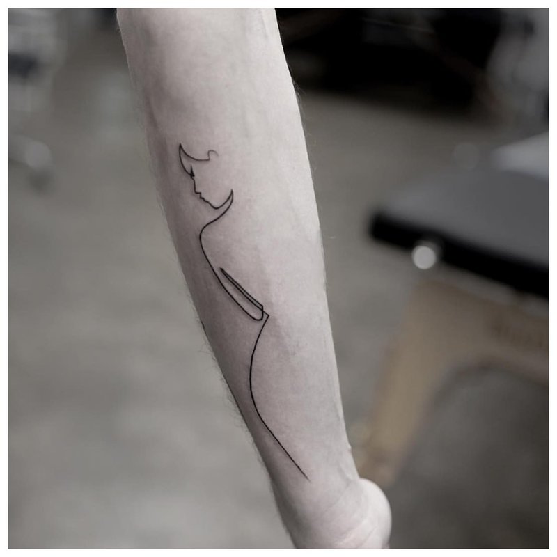 Vrouwensilhouet - tattoo op de arm van de man
