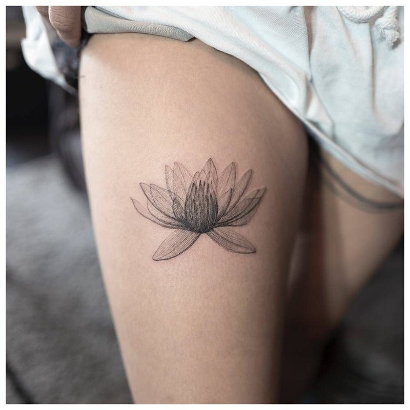 Gevoelige bloem - tatoeage op het been van het meisje