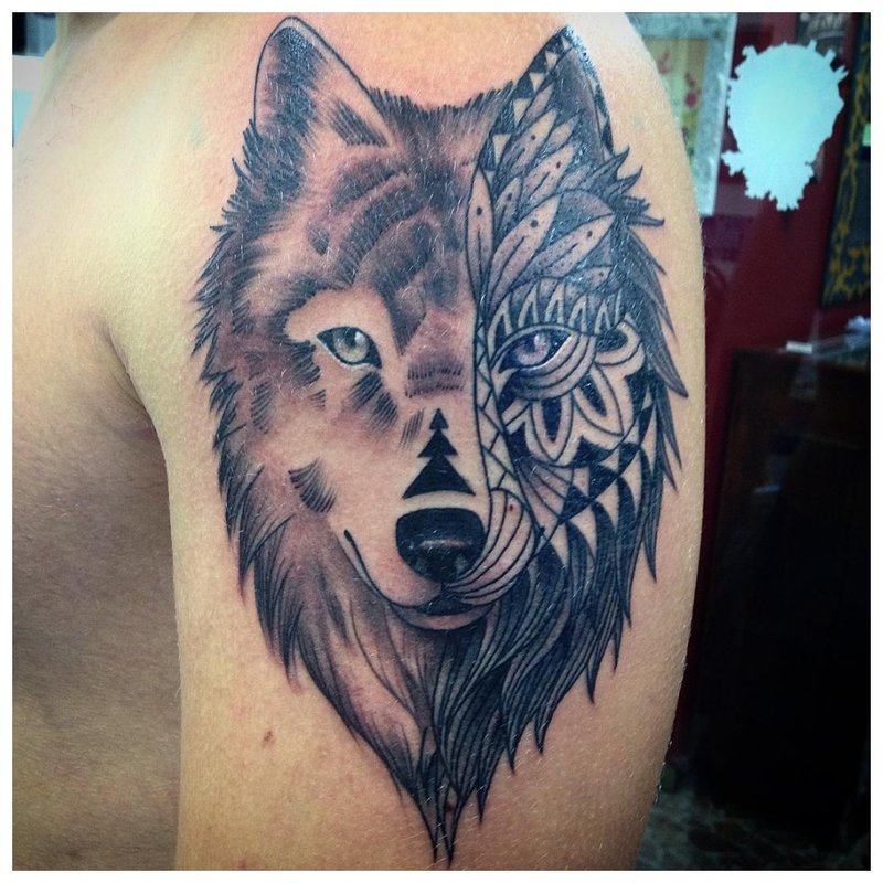 Különböző stílusú farkas tetoválás a vállán