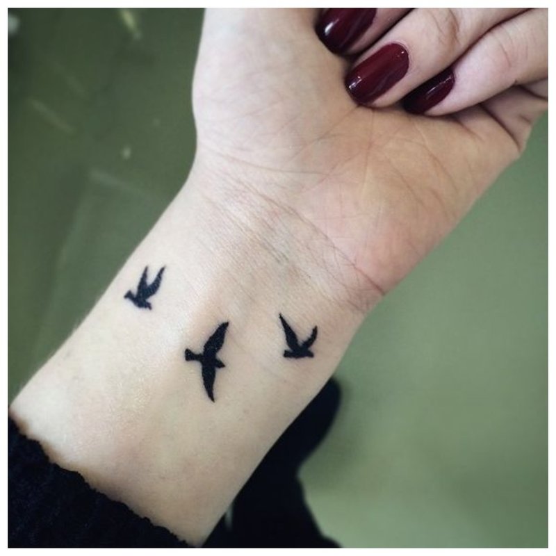 Tatuiruotė paukščių pavidalu ant mergaitės rankos