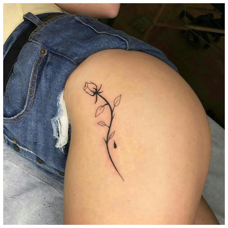 Татуировка на бедрото на момиче под формата на нежно цвете