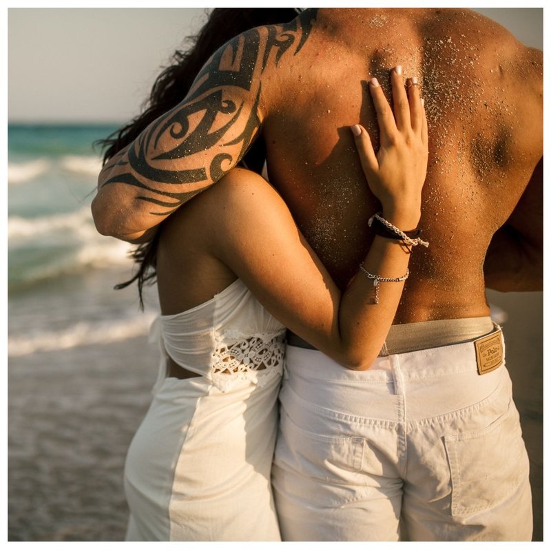 Para z tatuażami na plaży.