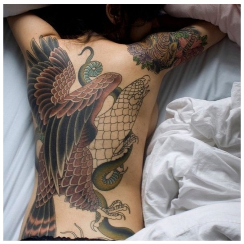 Meisje met oosterse tatoeage op haar rug.