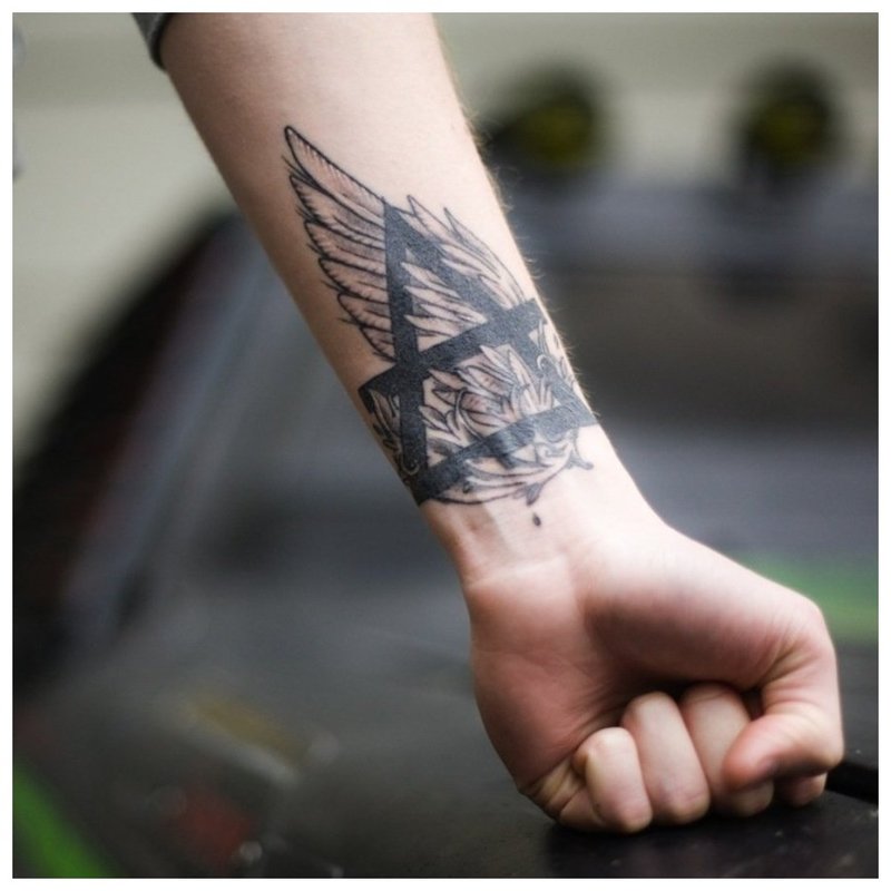 Szimbolikus tetoválás egy férfi karját