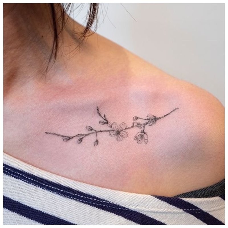Skånsom tatovering på kragebeinet til en jente