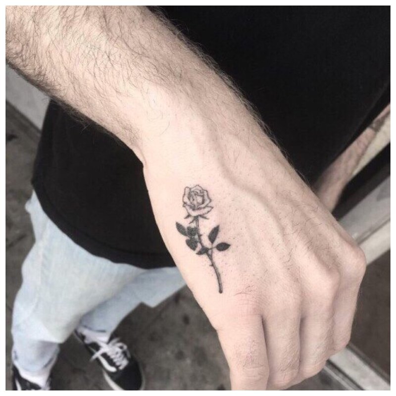 Mała róża - tatuaż na dłoni mężczyzny