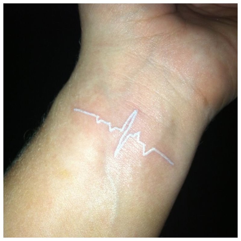 Balta tatuiruotė pulso ženklo pavidalu