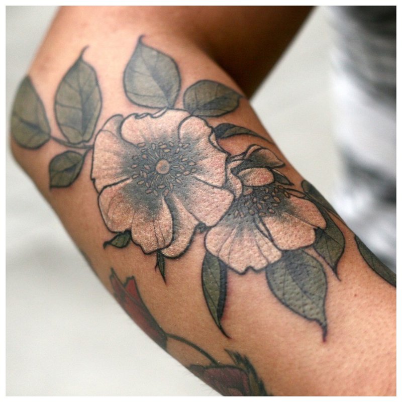 Tatuaj mare de flori pe brațul unei fete