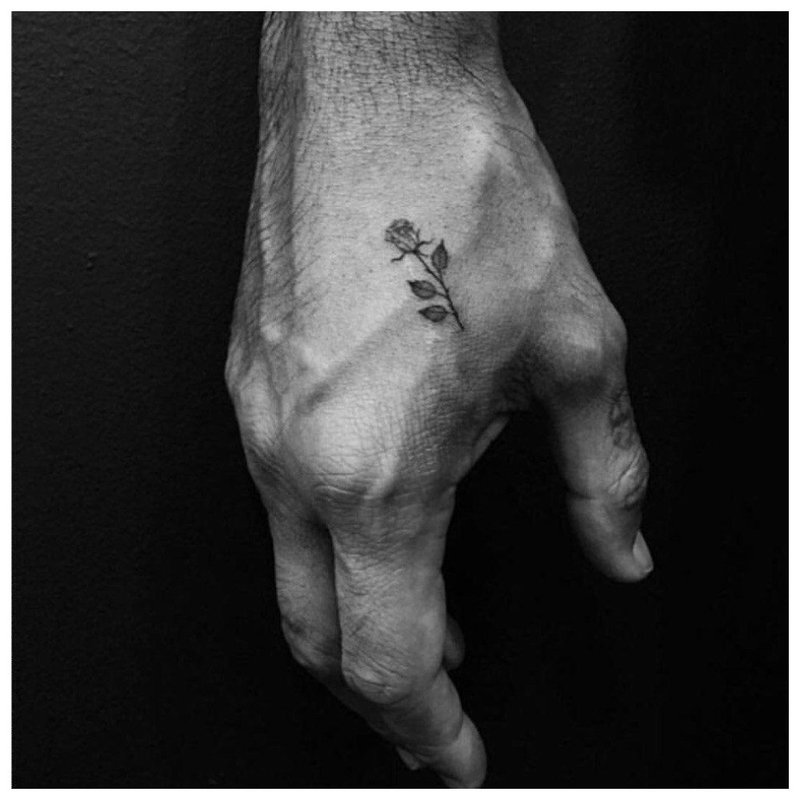 Lille rose - tatovering på en manns hånd