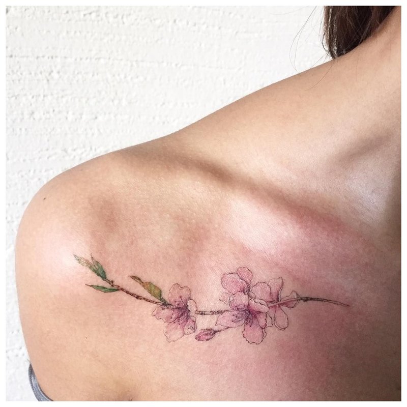 Delikatny tatuaż kwiatowy na obojczyku
