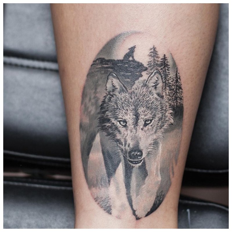 Wolf-tatoeages op het kalf van een man