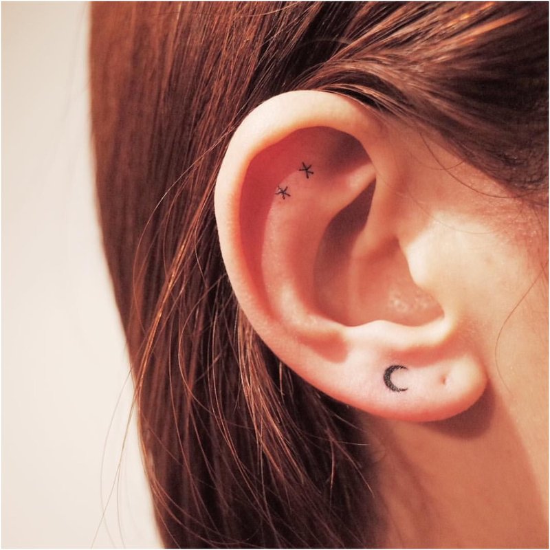 Bardzo minimalny tatuaż na uchu