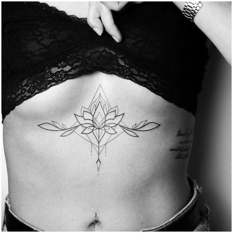 Delikatny tatuaż kwiatowy pod klatką piersiową
