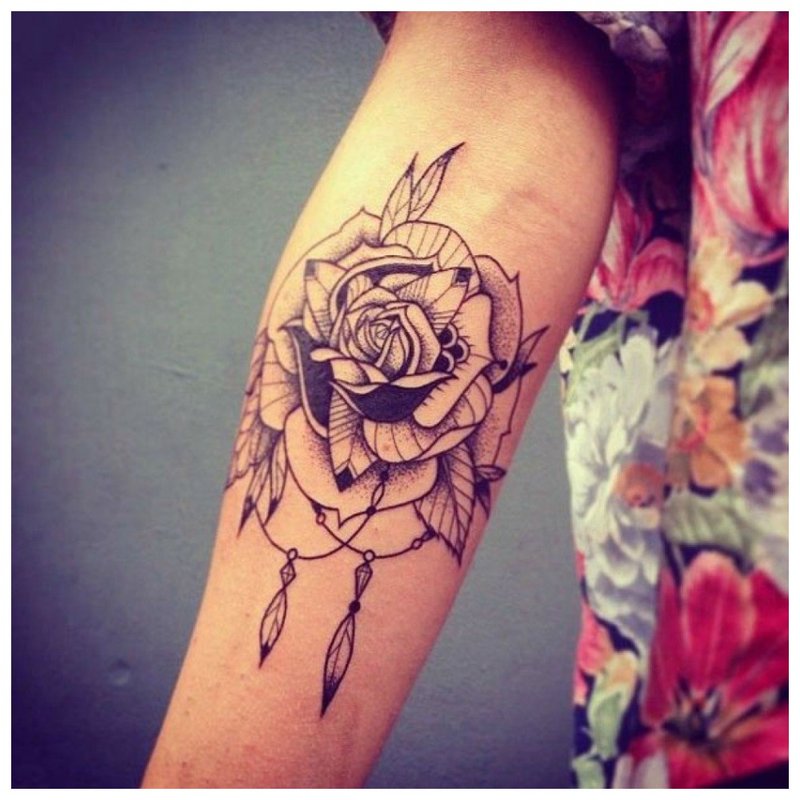 Tatoeage op de hand van het meisje in de vorm van een roos