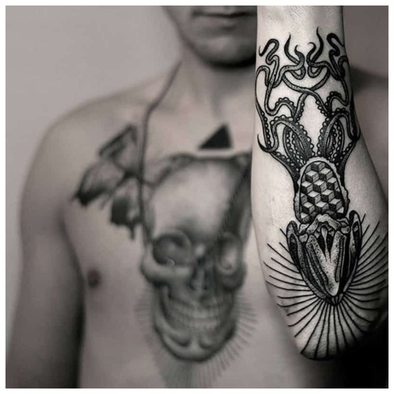 Fekete tetoválás az alkaron és a mellkason