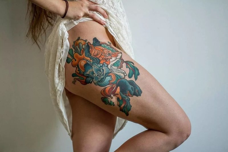 Kleurrijke tatoeage op de heup van een meisje