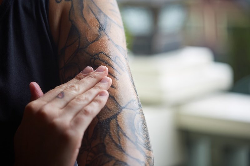 Meisje smeert een tatoeage met zalf