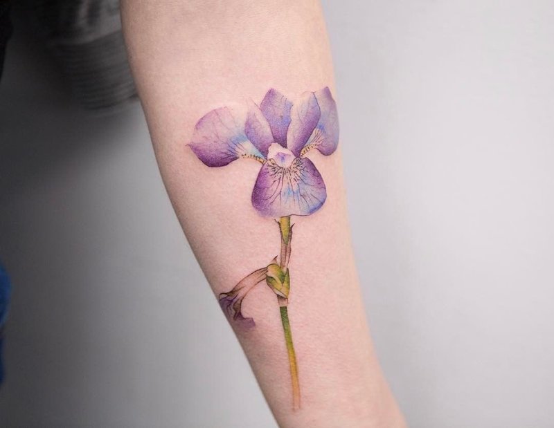 Akvarell blomster tatovering på underarmen