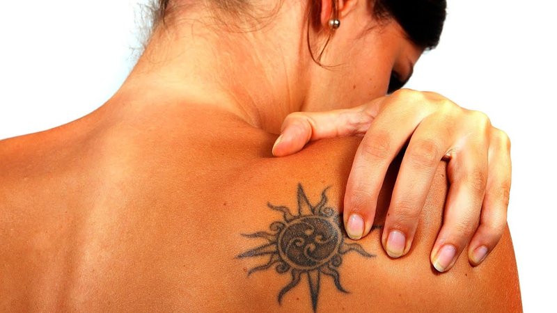 Dievča s tetovaním po opaľovaní