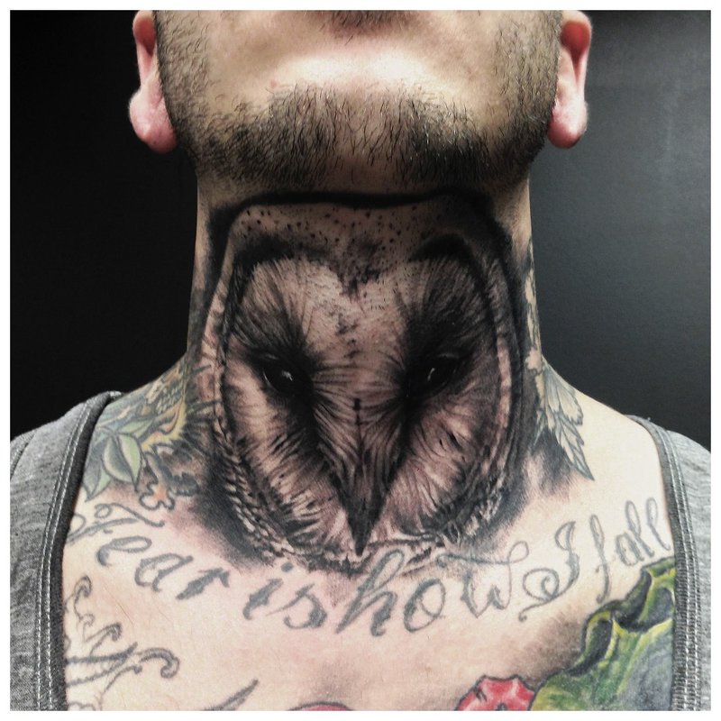 Tatuaje de búho en el cuello delante de un hombre