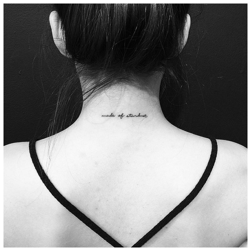 Inscripción de tatuaje en el cuello en la espalda