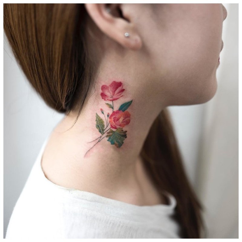 Heldere bloem in de nek van het meisje - tattoo